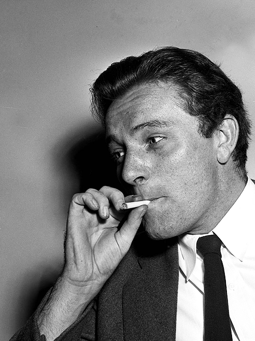 1952. A portrait of Welsh film star Richard Burton smoking a cigarette.